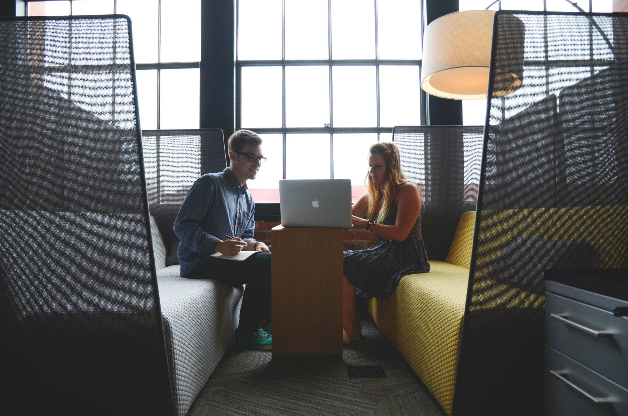 Two professionals working together on a laptop during a one-on-one meeting.